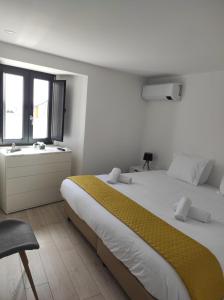 ein weißes Schlafzimmer mit einem großen Bett und einem Fenster in der Unterkunft Casinha das Bonecas By Viva a Vida - Alojamentos & Hotels in Constância