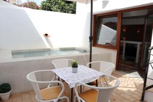 une terrasse avec une table et des chaises ainsi qu'une piscine dans l'établissement Patio de Agua de Alvor, à Alvor