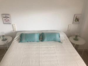 1 cama blanca con 2 mesas en un dormitorio en Cullera - Apartamento con piscina, tenis y club social, en Cullera