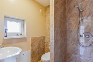 a bathroom with a shower and a toilet and a sink at Vila „Prie tvenkinio“ in Palanga +26 photos