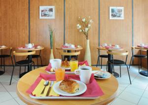 een tafel met een bord eten bovenop bij Séjours & Affaires Strasbourg Kleber in Straatsburg