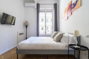 ミラノにあるLuxury 4 bedrooms apartments Close to Duomoの白いベッドルーム(大型ベッド1台、窓付)