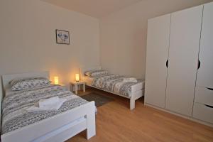 a bedroom with two beds and a dresser in it at Apartman F&F 2 in Otočac