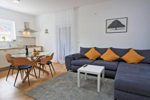 a living room with a blue couch and a table at Apartman F&F 2 in Otočac