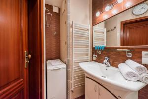 Baño pequeño con lavabo y espejo en Metro Wilanowska Homely Apartment, en Varsovia