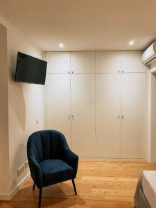 a living room with a chair and a television at Concha Setúbal Miradouro in Setúbal