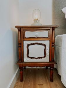 a nightstand with a lamp on it next to a bed at Concha Setúbal Miradouro in Setúbal