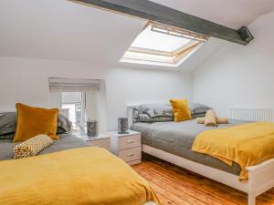 a bedroom with two beds and a skylight at Harbour Retreat in Millom