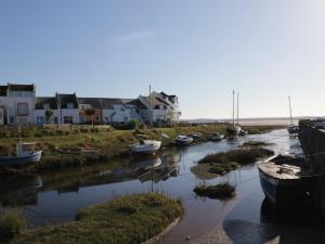 a group of boats in a river with houses at Harbour Retreat in Millom