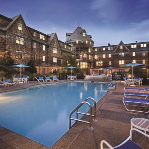 a large pool with chairs and umbrellas in front of a hotel at Club Wyndham Long Wharf in Newport