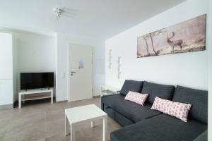 a living room with a couch and a tv at Cama 1 Apartment by Quokka 360 - Comfortable Stay in the Moesano Valley in Cama
