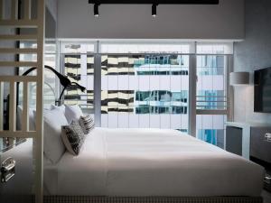 una camera con un letto bianco e una grande finestra di Southside by Ovolo a Hong Kong