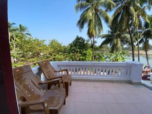 2 sillas sentadas en un balcón con vistas al océano en Rock N riveR, en Malpe