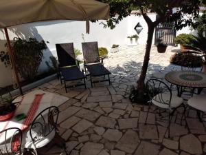 a patio with chairs and a table and an umbrella at Villa Dafne con ampio giardino, pochi minuti dal mare Fondi Sperlonga in Fondi