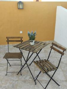 une table de pique-nique avec deux bancs et une plante en pot dans l'établissement Casa do Pátio em Alcantarilha - Algarve, à Alcantarilha