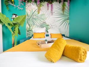 um quarto com uma cama com almofadas amarelas e laranja em Jungle studio proche de la gare em Grenoble