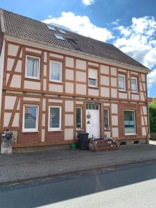 una casa marrone e bianca con una porta bianca di 2 Zimmer Whg a Langelsheim