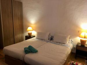 - une chambre avec un lit et une serviette verte dans l'établissement Casa do Pátio em Alcantarilha - Algarve, à Alcantarilha