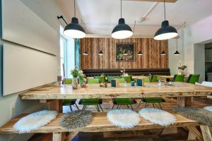 une salle à manger avec une grande table en bois et des chaises vertes dans l'établissement Gesäuse-Lodge, à Gstatterboden