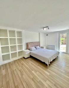 een slaapkamer met een bed en een houten vloer bij Appartement spacieux et moderne avec un extérieur in Ramatuelle