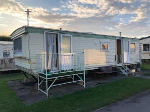 a mobile home with a porch and a deck at Fantasy Island and Beach 6 Berth 545 in Ingoldmells