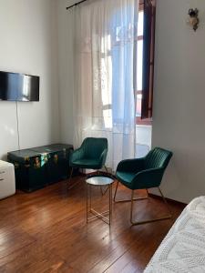 2 grüne Stühle und ein Tisch in einem Schlafzimmer in der Unterkunft Dimora Ferraris in Càbras