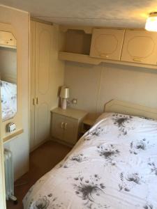 a small bedroom with a bed and a lamp at Fantasy Island and Beach 6 Berth 545 in Ingoldmells