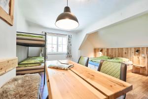 Habitación con mesa de madera y literas. en Gesäuse-Lodge, en Gstatterboden