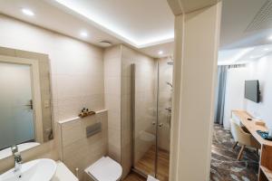 ein Bad mit einer Dusche, einem WC und einem Waschbecken in der Unterkunft Lábasház Debrecen in Debrecen