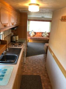 a kitchen with a stove and a couch in a room at Fantasy Island and Beach 6 Berth 545 in Ingoldmells