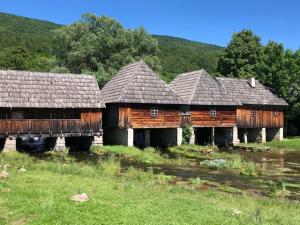 a group of old wooden buildings in a field at Apartman F&F 2 in Otočac