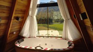a bath tub in a room with a window at Vista dos Canyons in Praia Grande