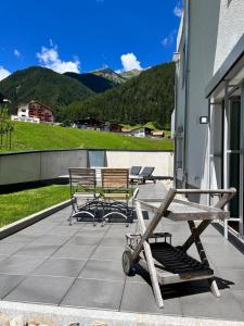 un patio con sillas y mesas en un edificio en Arlberg Mountain Resort, en Pettneu am Arlberg