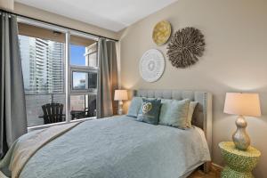 a bedroom with a bed and a large window at GLOBALSTAY BMO Centre and Downtown Apartments in Calgary