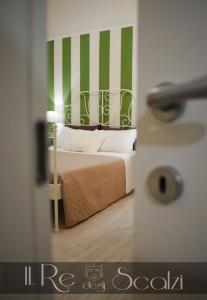 マテーラにあるIl Re degli Scalziの緑と白のストライプのベッド1台が備わるベッドルーム1室