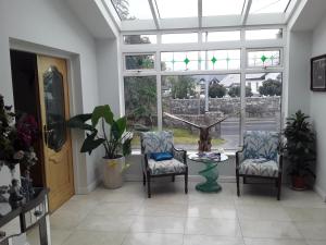 um quarto com duas cadeiras, uma mesa e uma janela em Ardan Mhuire em Galway
