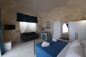 1 dormitorio con 1 cama azul y 1 sofá en B&B Talino, en Trani