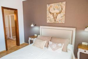 a bedroom with a white bed with pillows and a painting at Villa Atlantic Ocean Private Pool Corralejo By Holidays Home in Corralejo