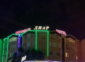 a hotel with neon signs on top of it at Diar in Atyrau