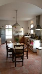 a kitchen with a table and chairs in a kitchen at La Ruette aux Loups in Collonges-au-Mont-dʼOr