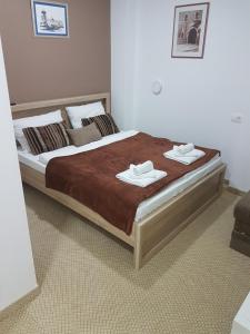 Apple Line Appartments في موستار: غرفة نوم عليها سرير وفوط