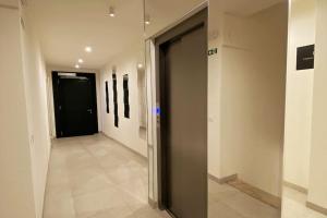 un couloir avec des portes noires et des peintures murales dans l'établissement Residenza SubitoSanto - Appartamento con balconcino "3B", à Padoue