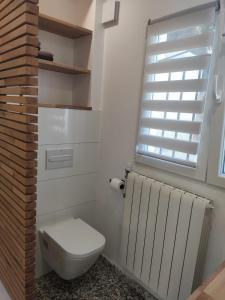 a bathroom with a toilet and a window and a radiator at Casa Muk in Calpe