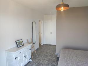 a bedroom with a bed and a dresser and a mirror at Casa Muk in Calpe