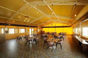 a restaurant with tables and chairs and yellow walls at The Fern Seaside Luxurious Tent Resort Diu in Diu