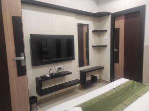 een kamer met een flatscreen-tv aan de muur bij Hotel Rudraksh- Near VIP Airport Guwahati in Guwahati