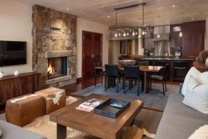 a living room with a couch and a kitchen with a fireplace at Platinum Vail Solaris 1 Bedroom Vacation Rental Set At The Base Of The Mountain Just Steps From The Gondola in Vail