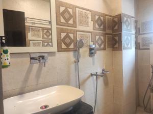 uma casa de banho com um lavatório e um chuveiro em Hotel Rudraksh- Near VIP Airport Guwahati em Guwahati