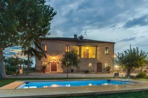 a stone house with a pool in front of it at BB Casale La Selva Mosciano in Mosciano SantʼAngelo