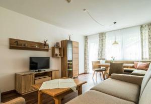 a living room with a couch and a tv at Ferienwohnanlage Oberaudorf in Oberaudorf